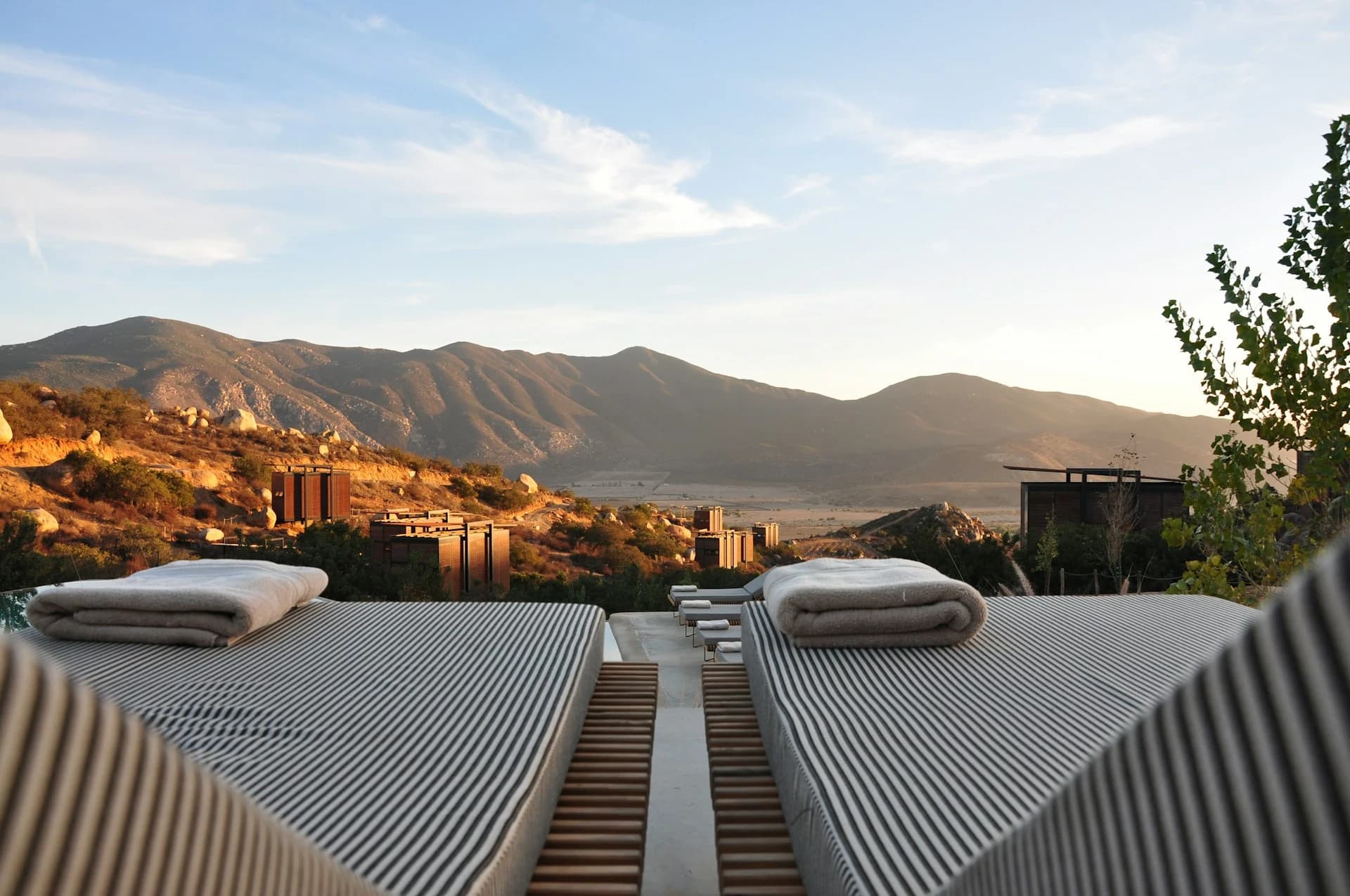 Loungers set out above a valley as the light goes